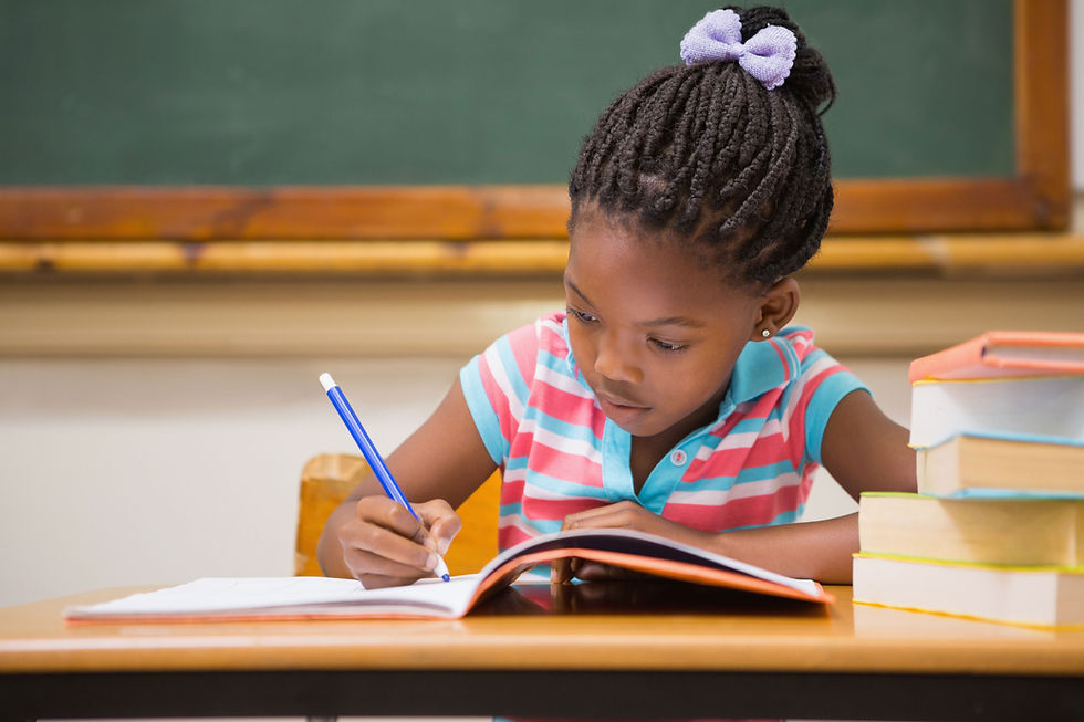 young girl writing in a notebook in a classroom
