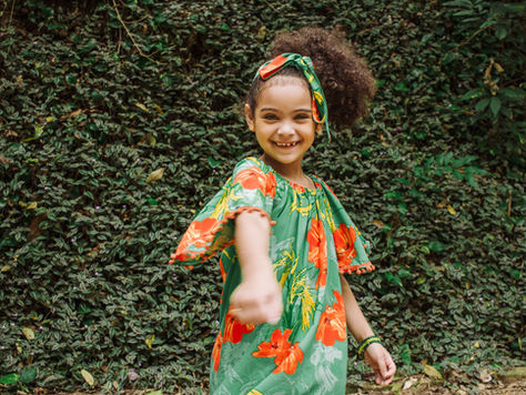 Parent brushing toddler’s coily hair while applying Crown Care Step 2 Conditioner for easy detangling.