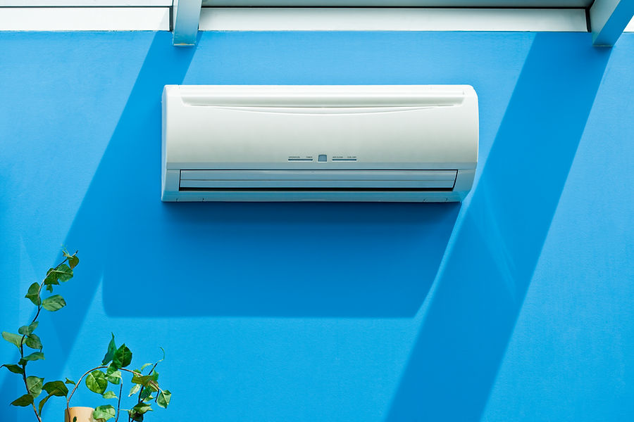 White air conditioner mounted on a vibrant blue wall