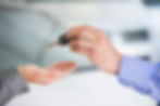 A person handing a car key to another person