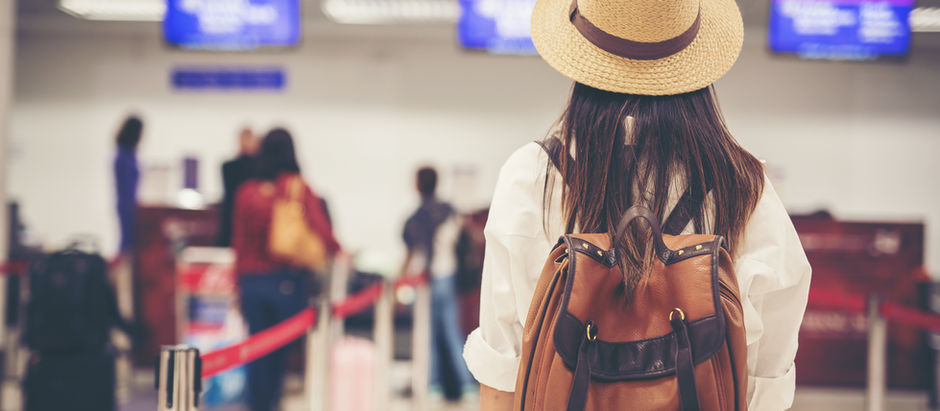 A woman stands in front of a passport security checkpoint.