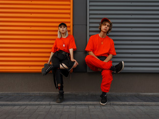 Male and female promotional model wearing red and black uniform during photoshoot