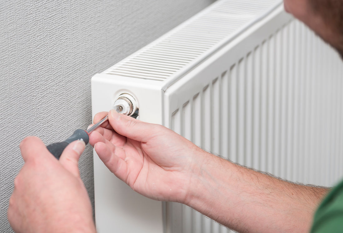 close-up image of a person's hand while using a tool to repair radiator