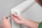 A plumber bleeding a radiator valve