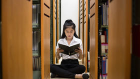 Female asian student reading in the library in Hong Kong