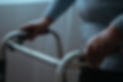 A close-up of an elderly person's hands gripping a walking frame