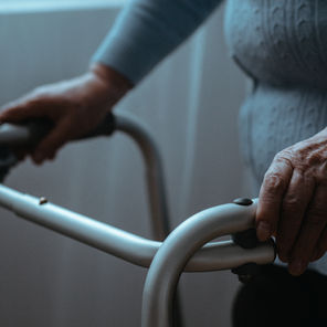 An elderly person holding a walking support device.