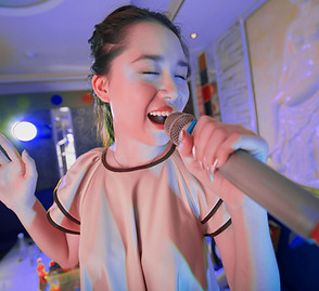 Asian woman singing in a karaoke