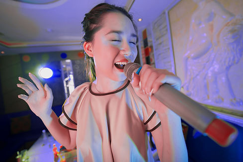 Asian woman singing in a karaoke