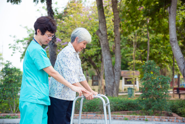 Care worker supporting an elderly woman