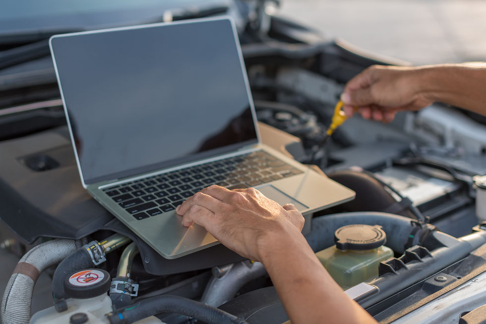 A mechanic uses a laptop computer to run diagnostic tests on a car engine