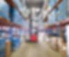 Warehouse worker lifting boxes from shelf with forklift