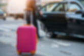 People taking taxi from an airport and loading carry-on luggage bag to the car. Luggage on