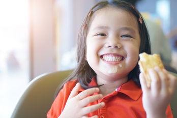 child smiling while eating during feeding and swallowing therapy 