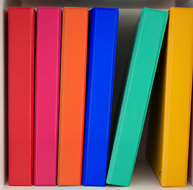 A row of brightly colored binders lined up side by side.