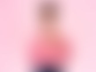 I woman with a smile on her face holds her hands to her heart.