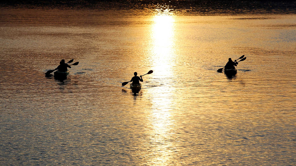3 kayaks on the water at sunset