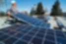 Workers installing solar panels on a residential home roof
