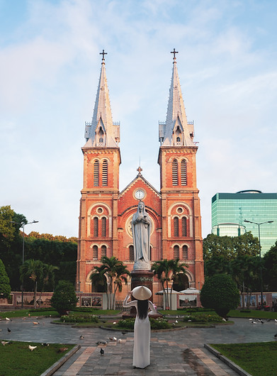 Vietnamese girl wearing ao dai standing in front of the Notre-Dame Cathedral Basilica of S