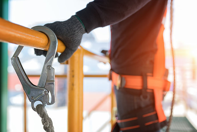 Construction worker wearing safety harness and safety line working at high place