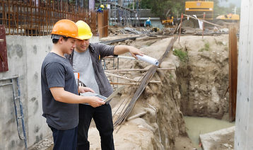 Dos ingenieros buscando información en el Imac en una obra