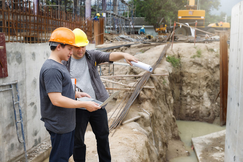 Two male engineers looking information on Imac at a construction site