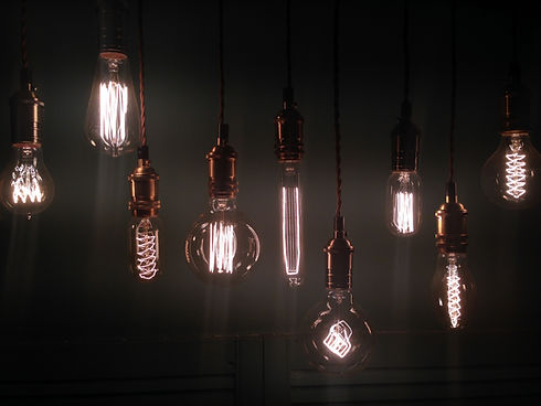 Selection of decorative vintage Edison filament lightbulbs hanging together against a dark background
