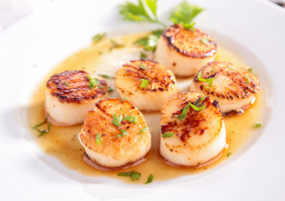 Pan-seared scallops with sauce.