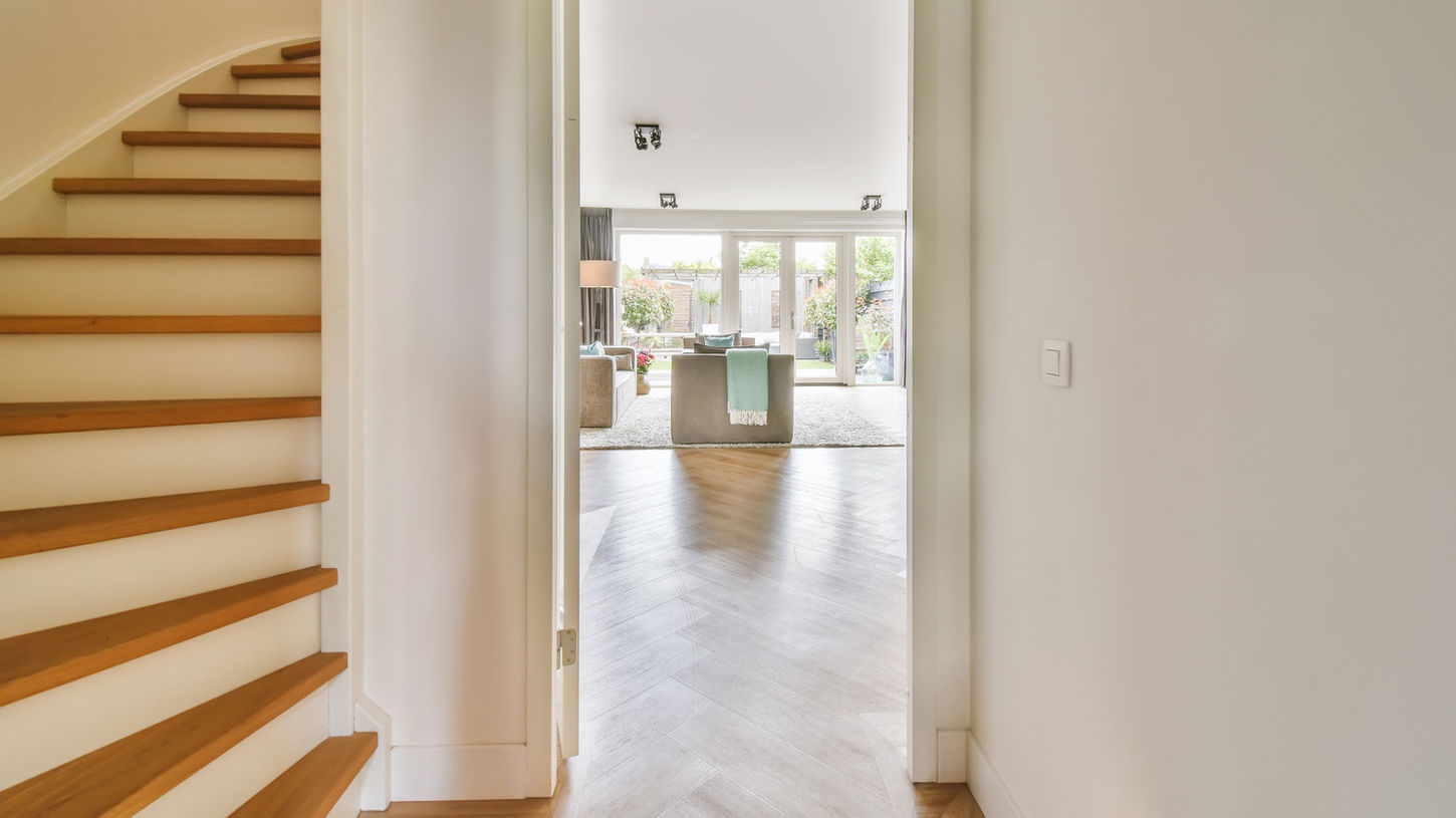 Modern home interior with light wood herringbone floors.