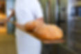 baker baking fresh bread, bread on a pizza paddle