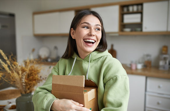 A young adult female smiles while sitting on a couch