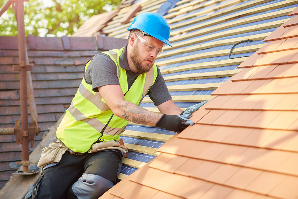 Construction worker in a safety vest inspecting clay roof tiles