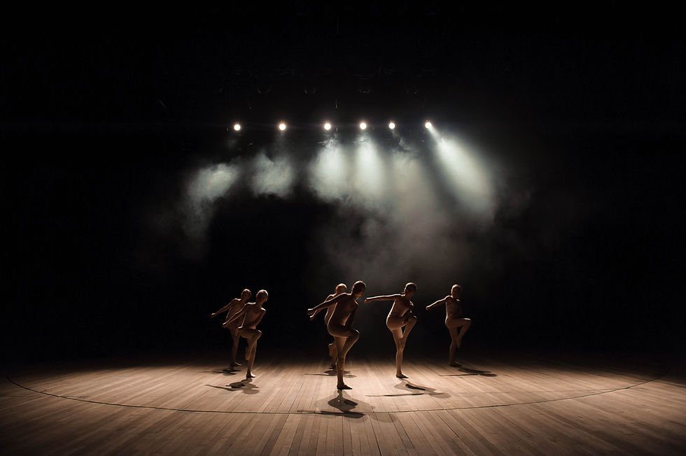 Troupe de danseurs sur scène en bois avec des projecteurs