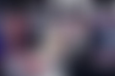 A news reporter standing behind the desk on set.