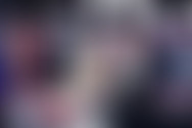 A news reporter standing behind the desk on set.