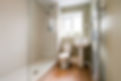 Light streaming in through the window of a compact, minimalist modern bathroom