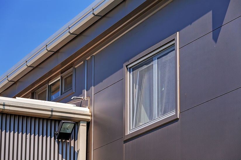 Details of grey facade made of aluminium panels with doors and windows