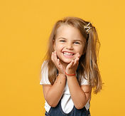 Petite fille souriante assise, représentant un patient en orthodontie pédiatrique