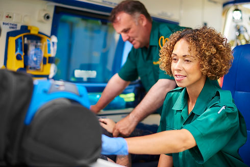 Two paramedics providing emergency care to patient inside ambulance