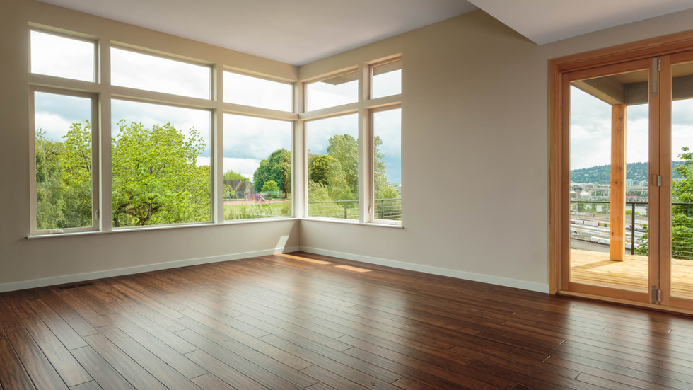 an empty room with hardwood floors and lots of windows