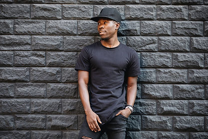 A person in a black t-shirt stands in front of a textured stone wall, with overlay text 'Closer Lives Emporium' in bold yellow, with 'mexican tile style' in bold white text beneath it.