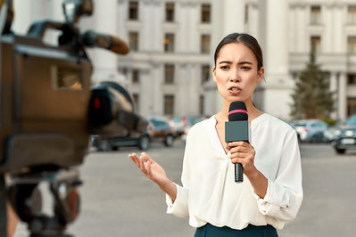 Journalist with microphone working on city street