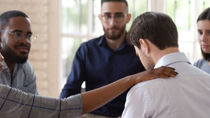 A woman showing support for a man in a support group.