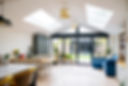 Interior of open plan living space in modern home extension with large patio doors to gard