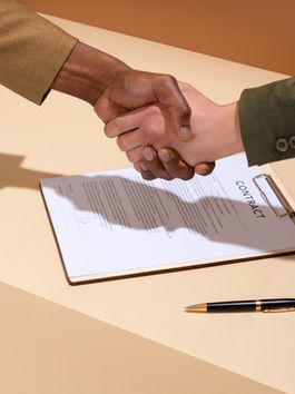 people shaking hands over a signed contract