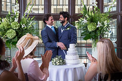 Two grooms cutting cake
