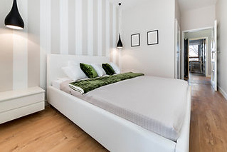 Modern bedroom in white finishing and wooden floor