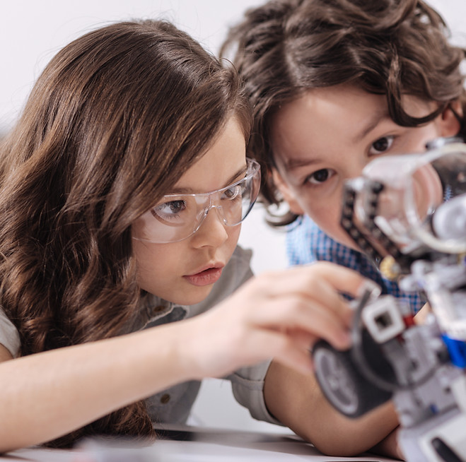 a girl and a boy learning how to build a robot