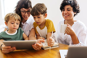 A smiling family gathers around a device