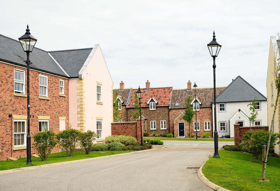 Brick houses and traditional landscaping on a quiet street in England in front of a gray s